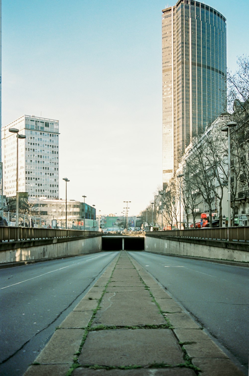 gray concrete road between high rise buildings during daytime