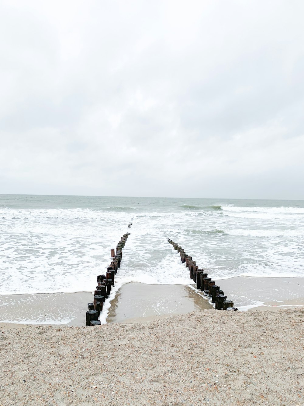 brown wooden dock on sea under white clouds during daytime