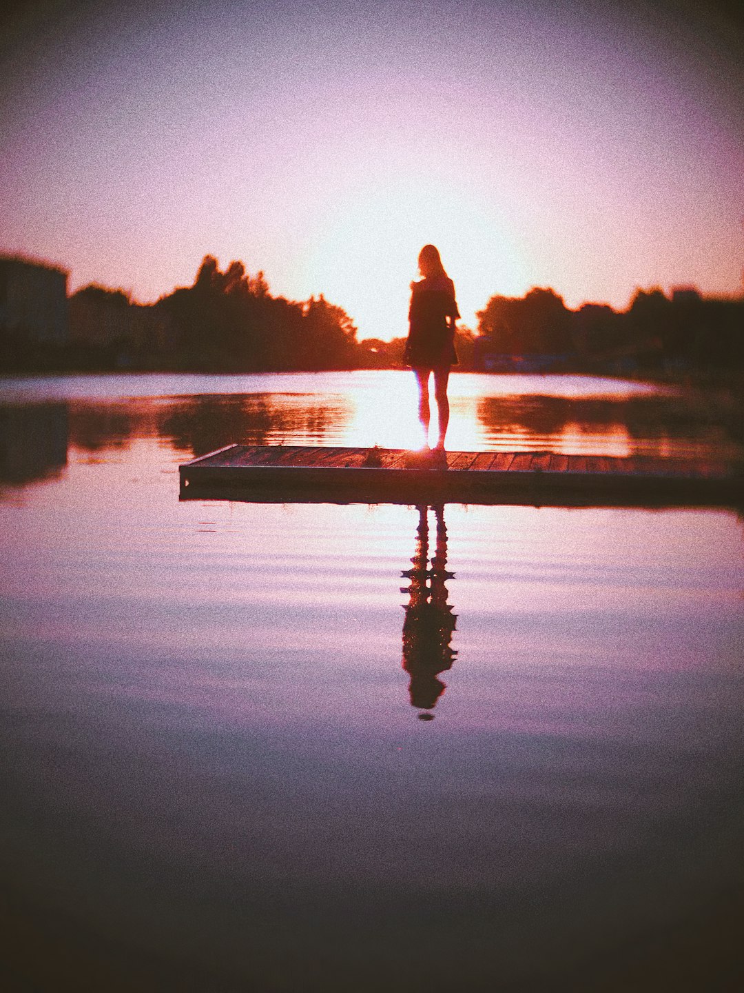 silhouette of man and woman standing on boat during sunset