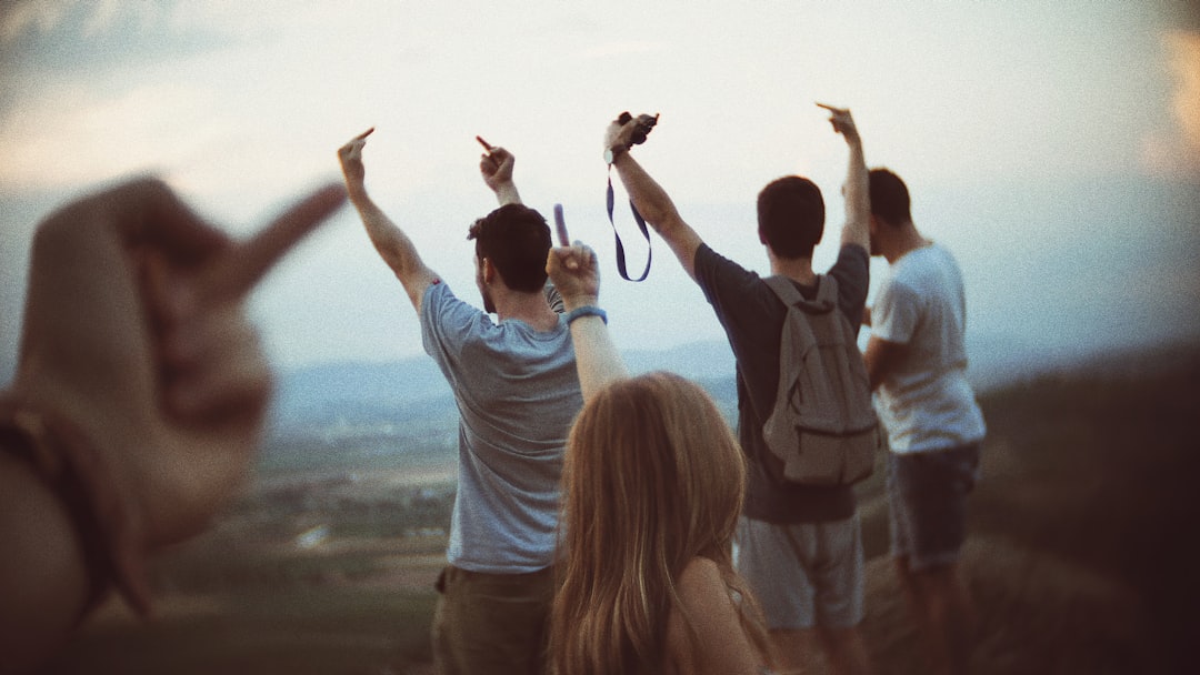 woman in white long sleeve shirt raising her hands