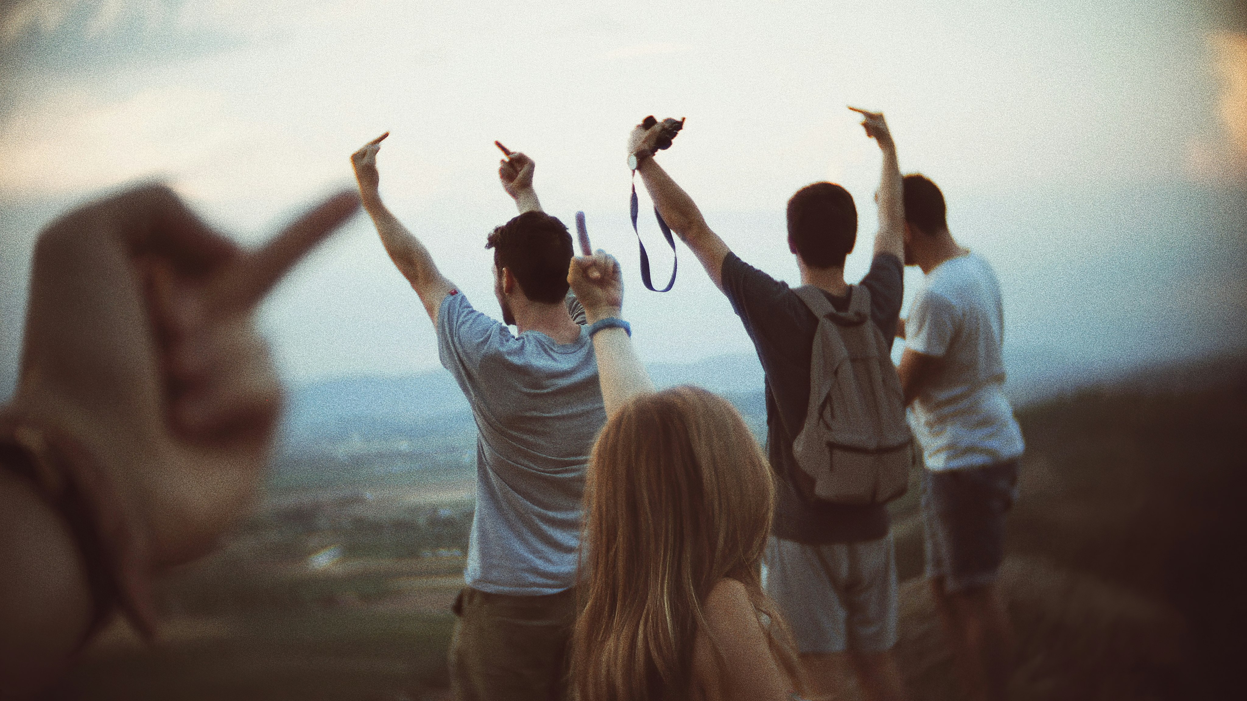 woman in white long sleeve shirt raising her hands