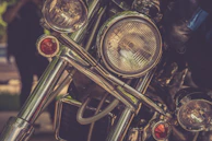 Close-up of shiny chrome detailing on a classic motorcycle against a blurred highway background.