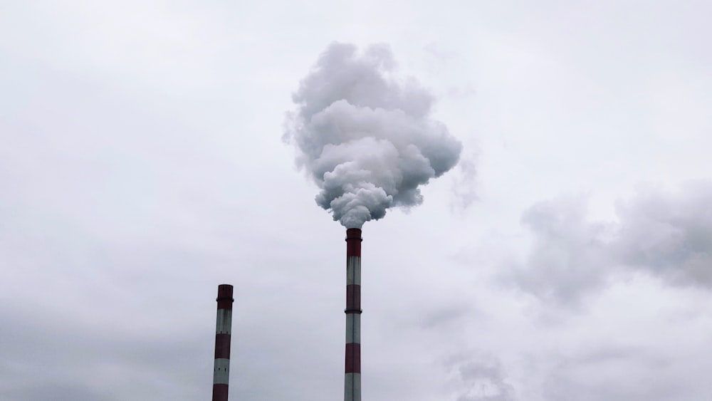 white smoke coming out from a white and black tower