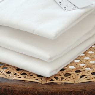 white textile on brown woven basket