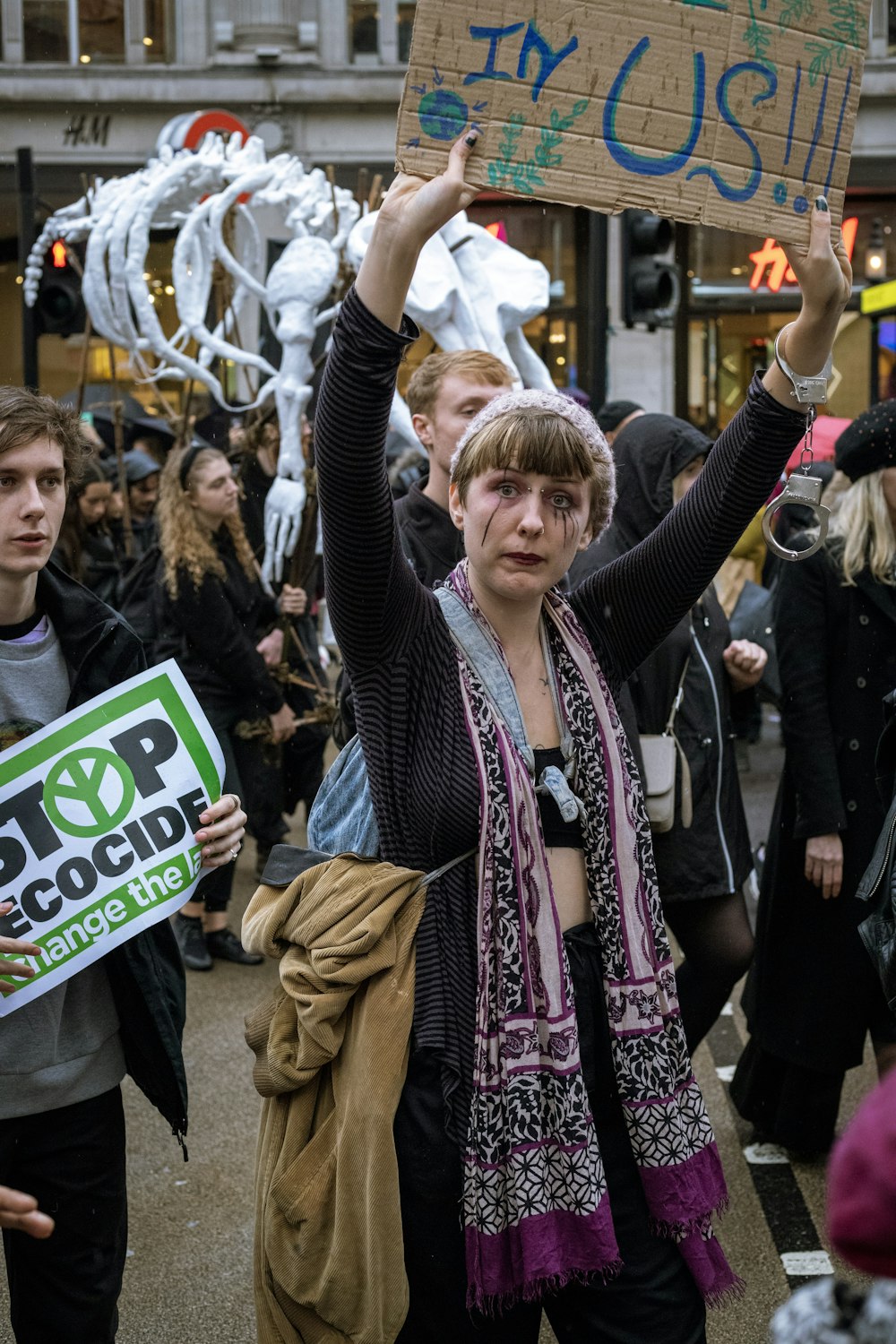 a woman holding a sign in the middle of a crowd