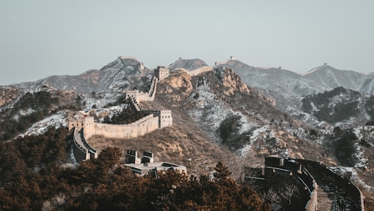 white and brown concrete building near mountain during daytime in Great Wall China