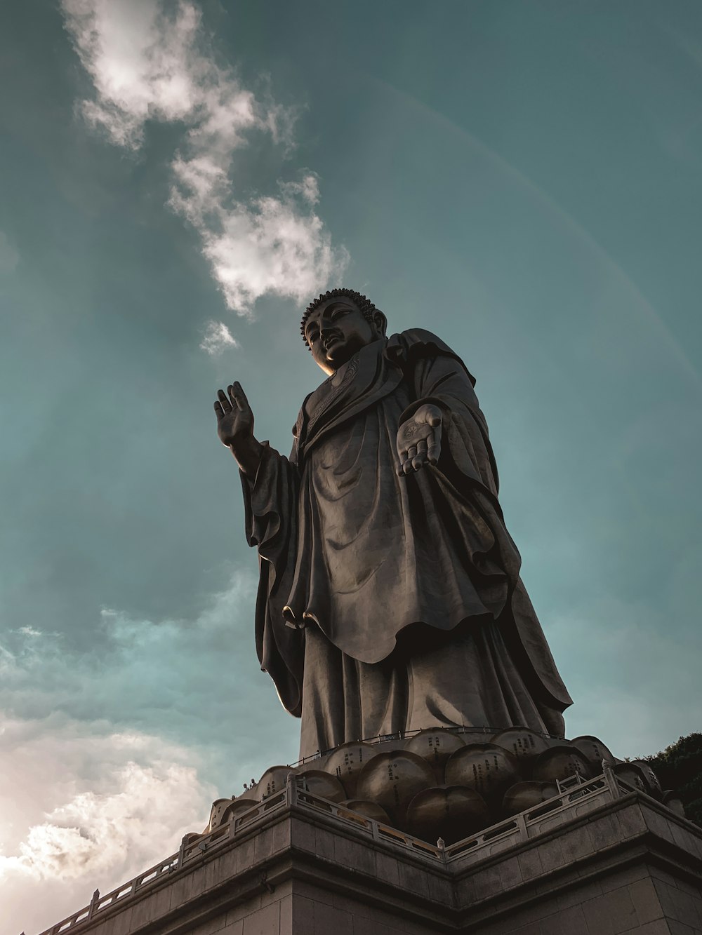 low angle photography of man statue under blue sky during daytime