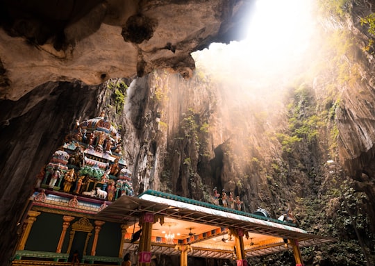 brown wooden houses near waterfalls during daytime in Batu Caves Malaysia