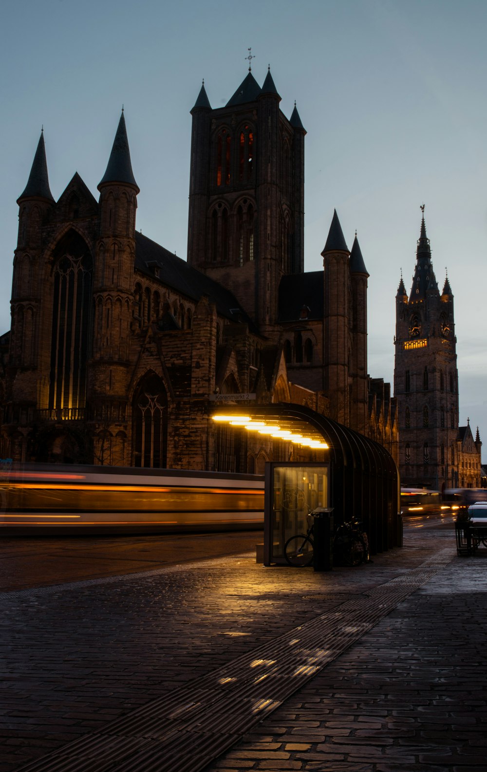 Photographie en accéléré de voitures sur la route près d’un bâtiment pendant la nuit