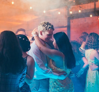 woman in white sleeveless dress kissing man in blue dress shirt