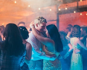woman in white sleeveless dress kissing man in blue dress shirt