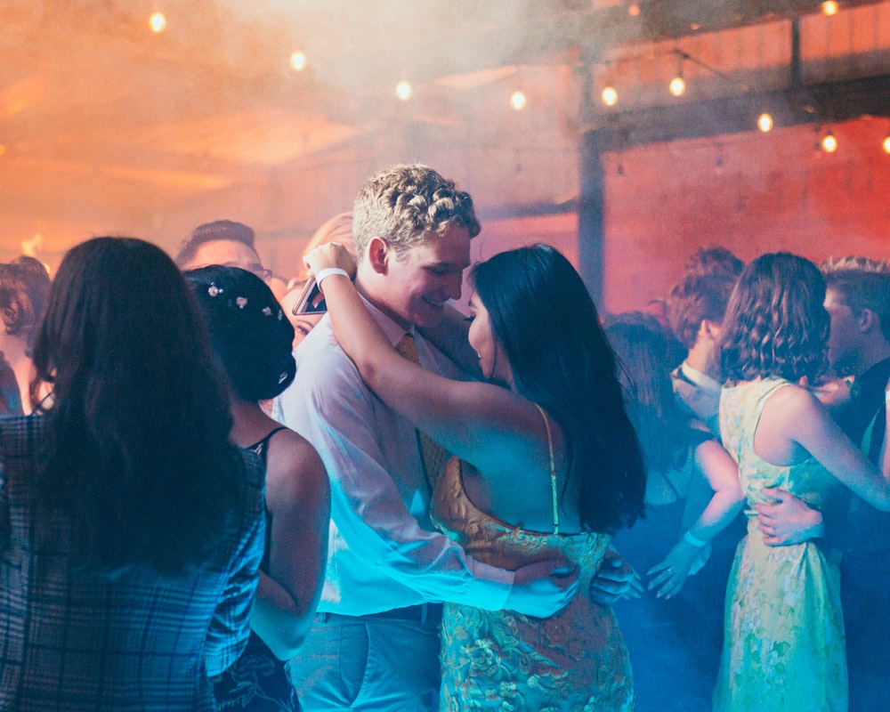 woman in white sleeveless dress kissing man in blue dress shirt