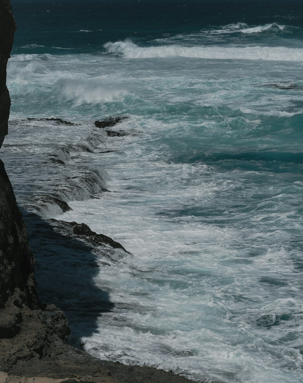 ocean waves crashing on rocky shore during daytime