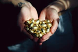 person holding brown and black round fruits