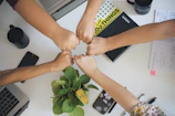 five fists bumping over office desk