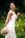 woman in white floral dress holding bouquet of flowers
