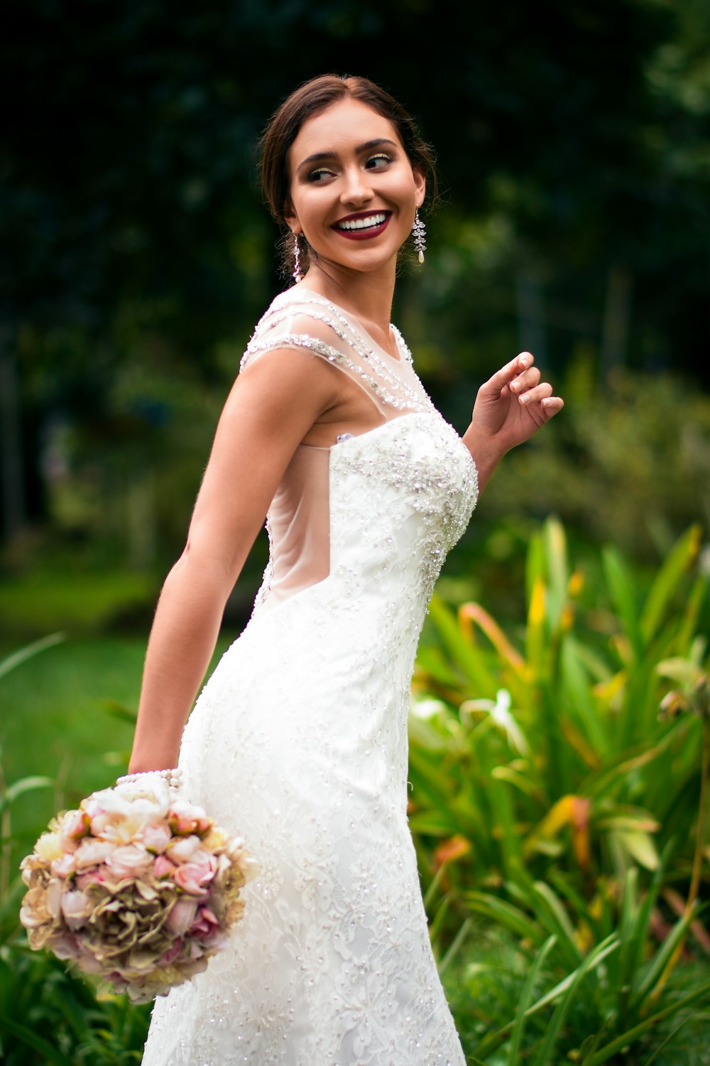 woman in white floral dress holding bouquet of flowers