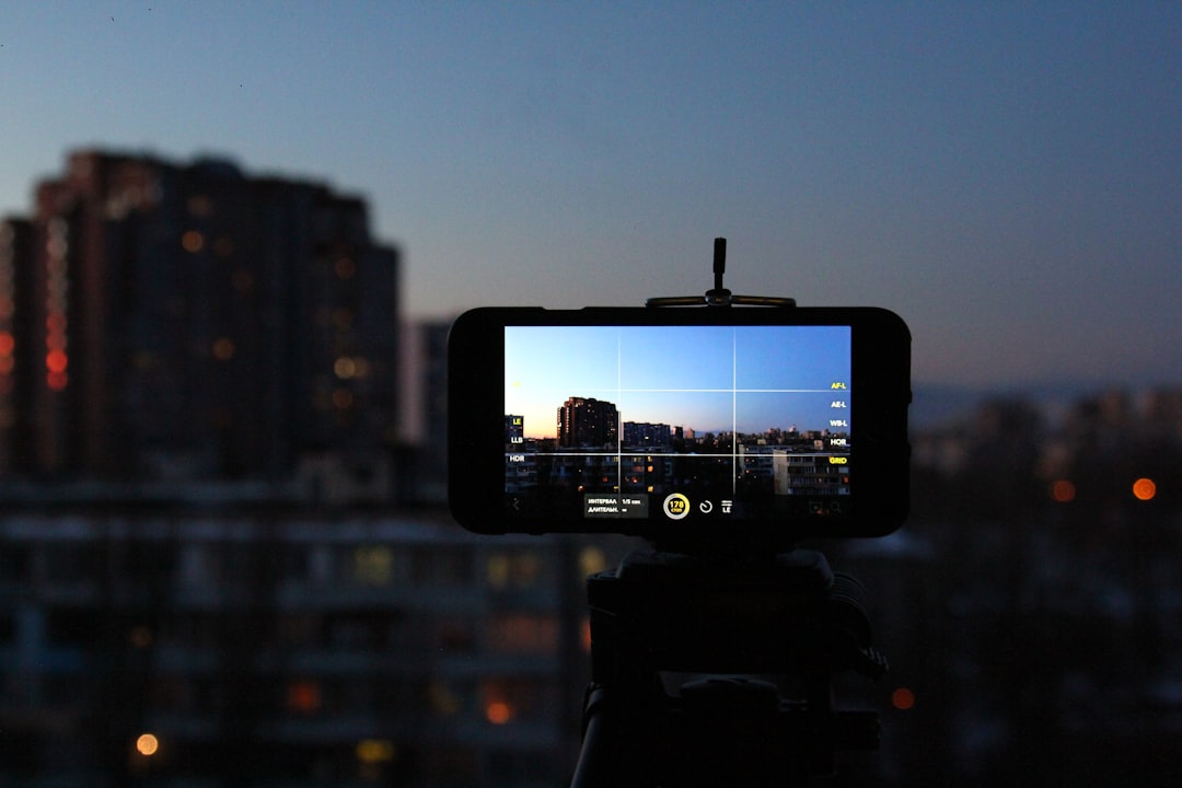 black smartphone taking photo of city buildings during night time