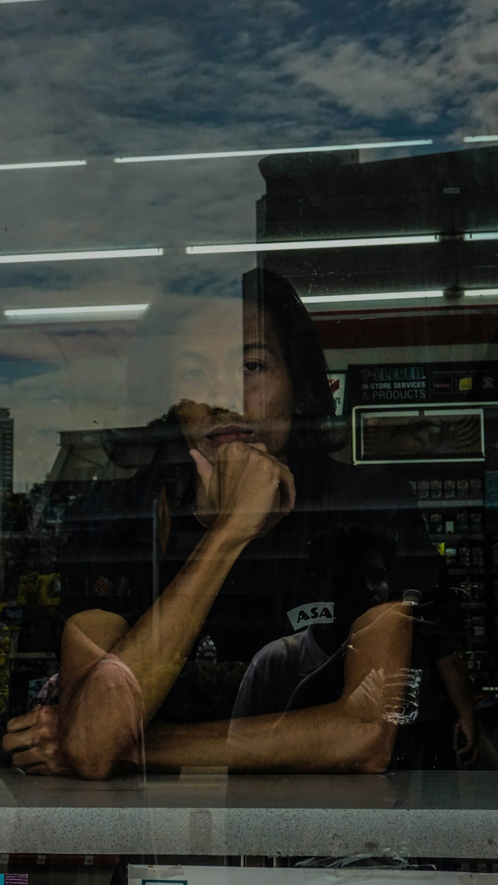 woman in black t-shirt standing near glass wall