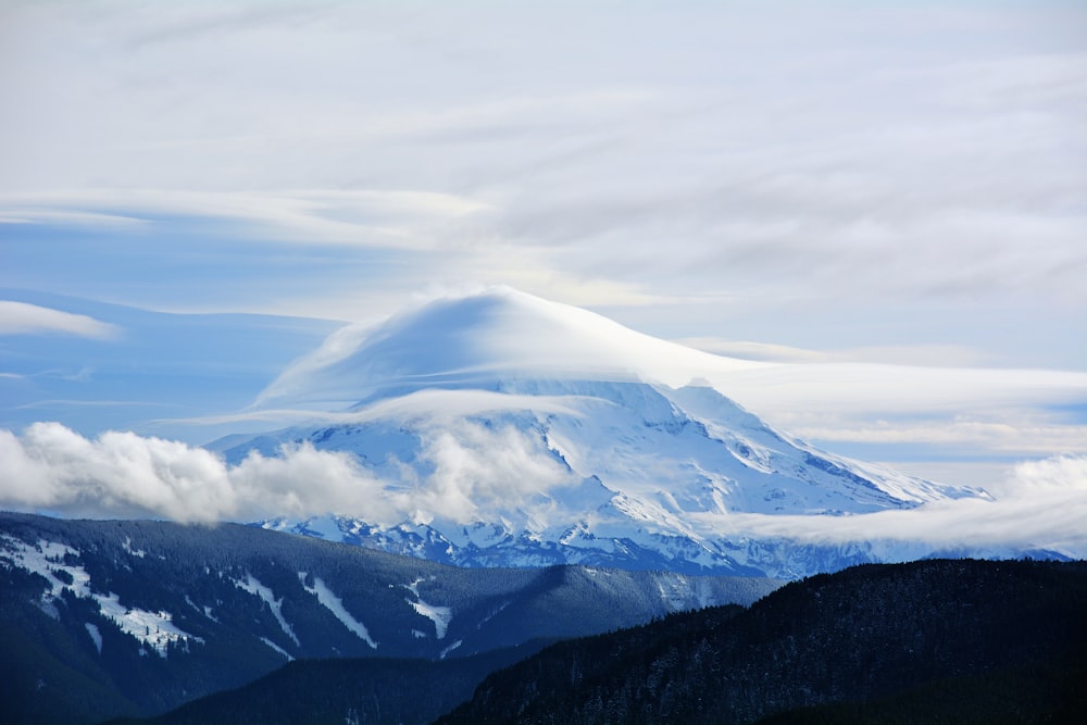 white clouds over snow covered mountains