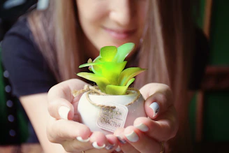 A candid shot of a woman’s hands tending to her orchid plants, embodying care and intentional living.