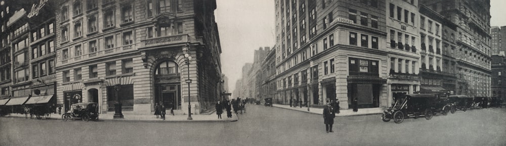 grayscale photo of people walking on street near building