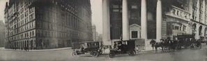 A black-and-white archival photo showing South Flower Street in the early 1900s with bustling storefronts and horse-drawn carriages.