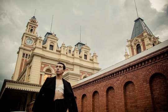 woman in black long sleeve shirt standing near brown concrete building during daytime in Luz Station Brasil