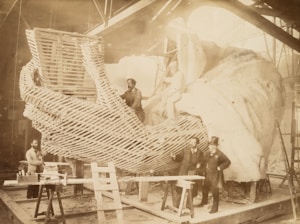 A group of enthusiastic students building a large cardboard sculpture during a workshop.