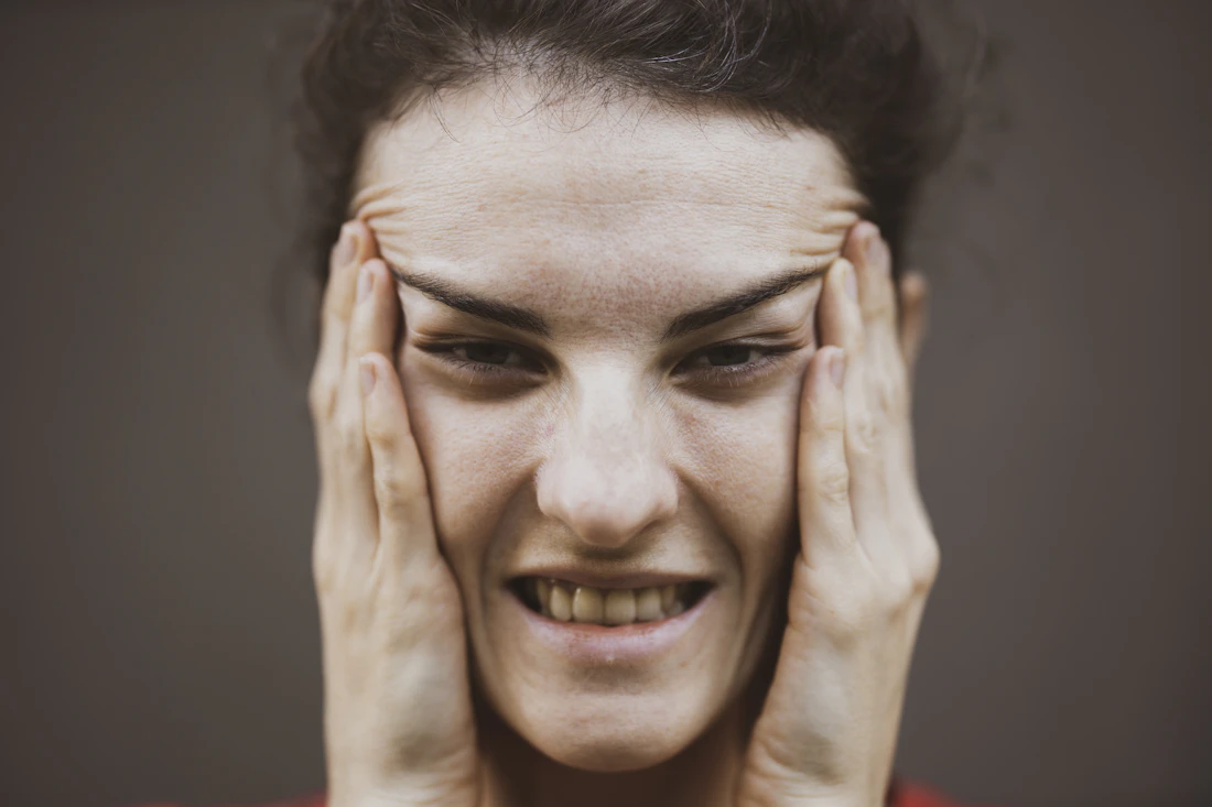 A woman experiencing jaw and head pain