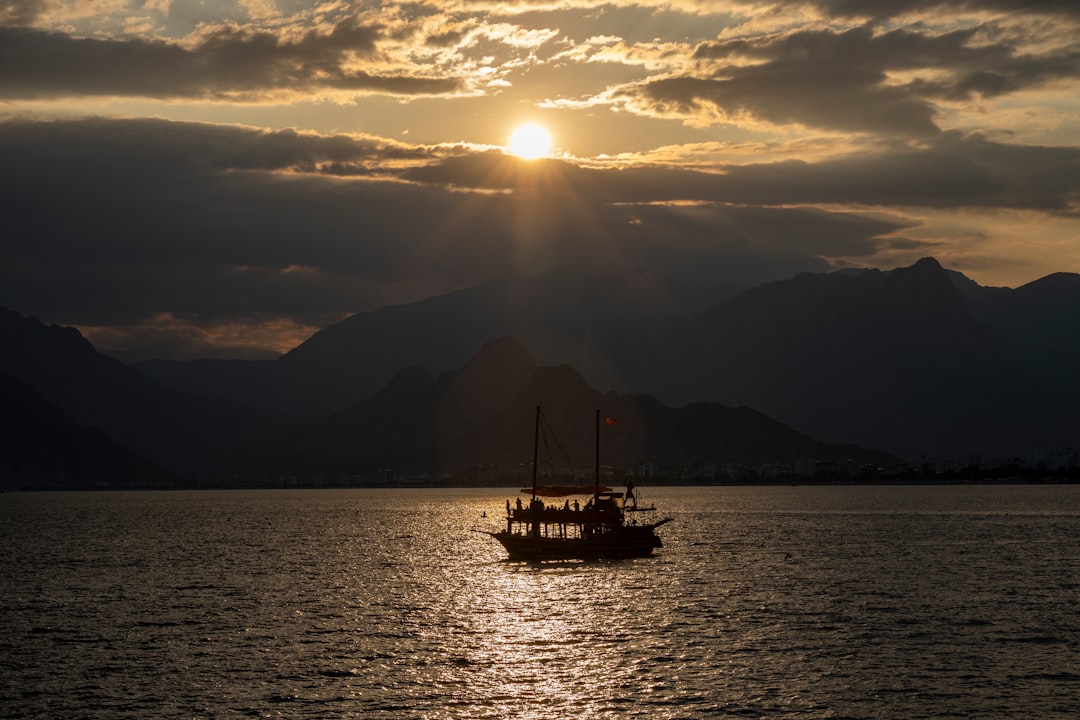 silhouette of boat on sea during sunset