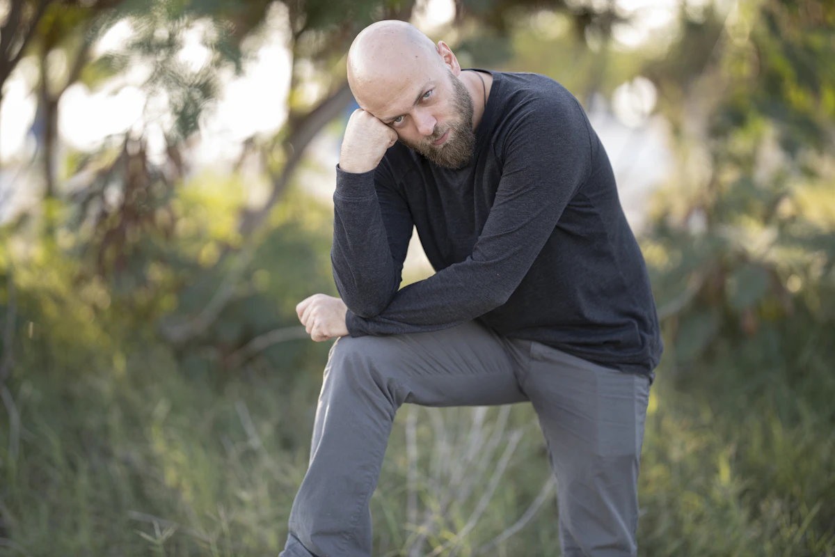 Active man outdoors holding his aching knee, illustrating joint pain that regenerative medicine can treat without surgery.