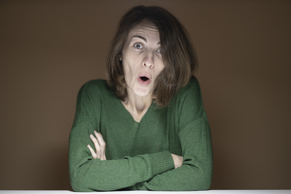 woman in green sweater with pink lipstick