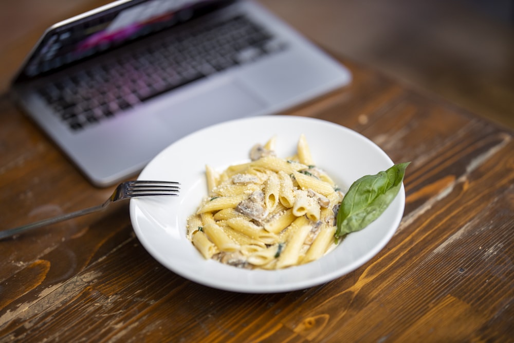 Plato de pasta sobre plato de cerámica blanca