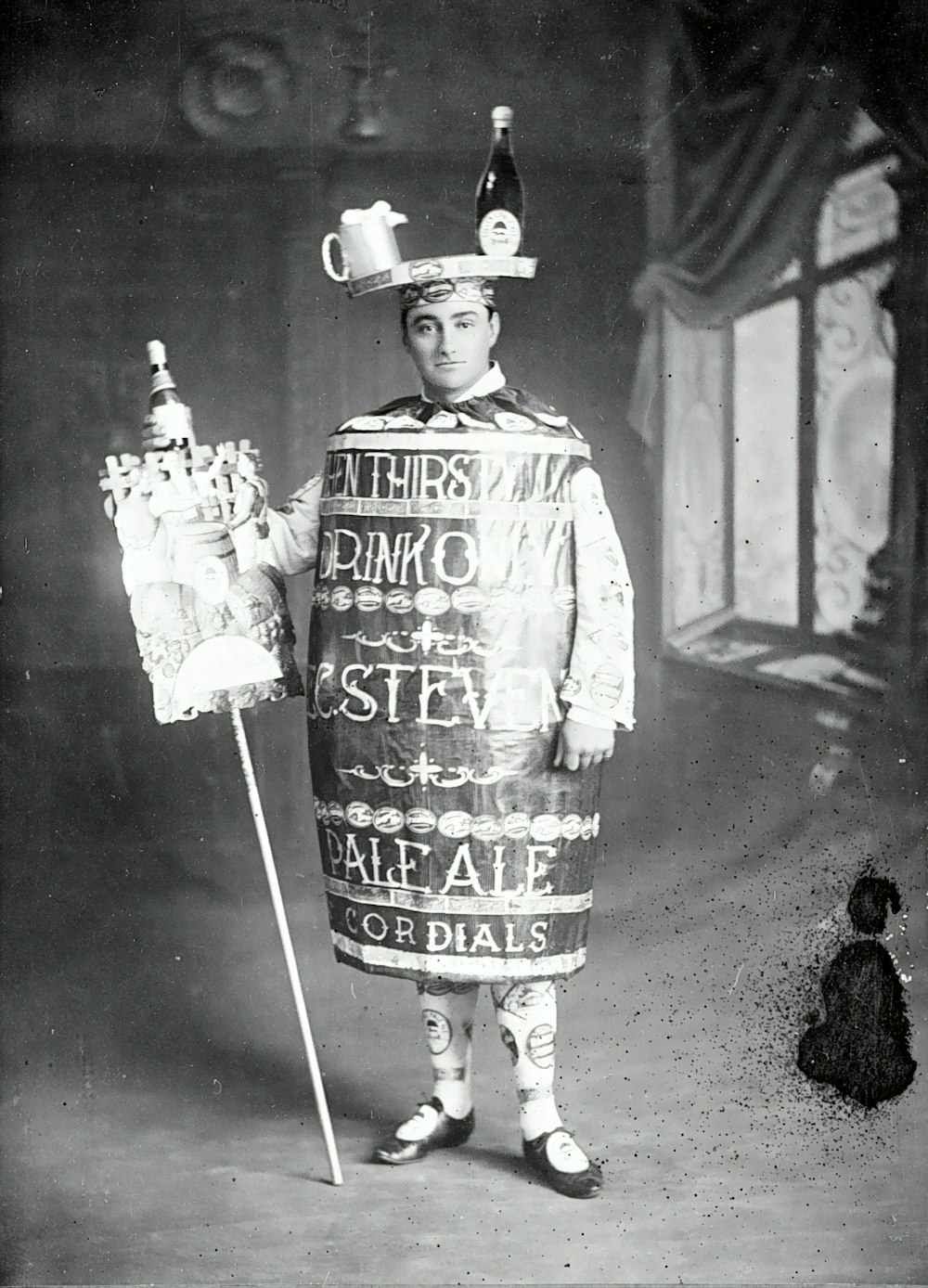 grayscale photo of man in hat holding stick