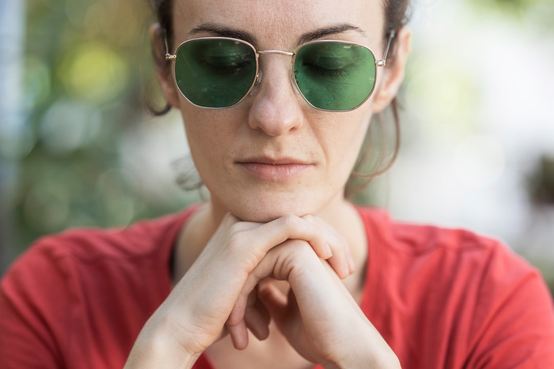 woman in red shirt wearing green sunglasses
