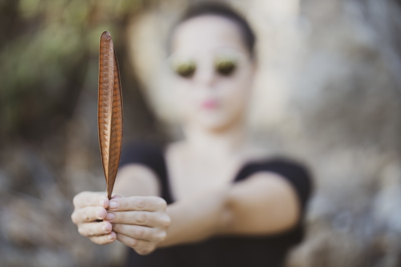 woman with autumn leaf in natural setting