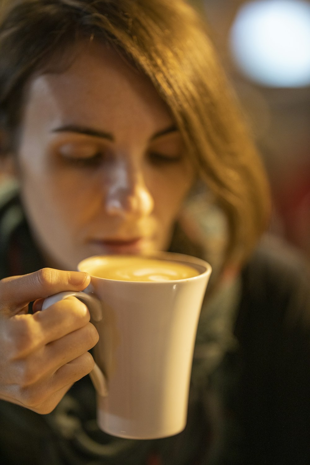 woman drinking on white ceramic mug