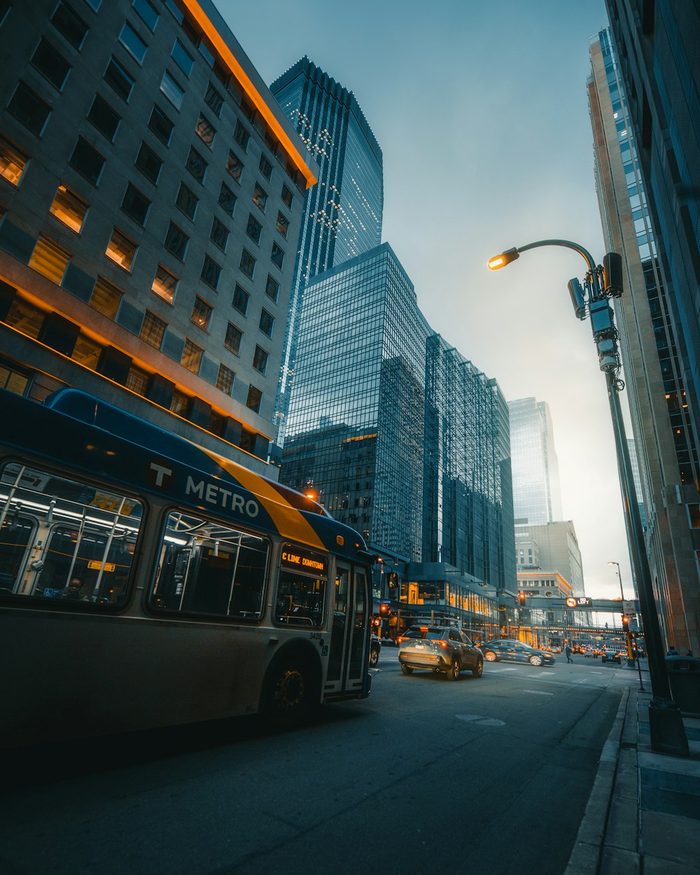 yellow bus on road near high rise buildings during daytime