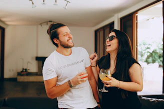 man in white crew neck t-shirt holding drinking glass