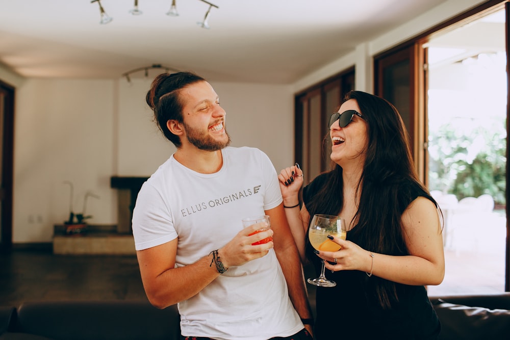 man in white crew neck t-shirt holding drinking glass