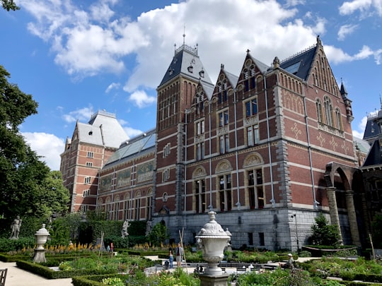 brown concrete building near green grass field during daytime in Rijksmuseum Netherlands