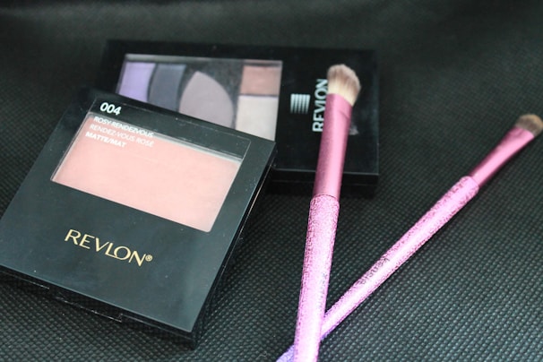 Beauty products featuring blush, eyeshadow palettes, and brushes in pastel tones