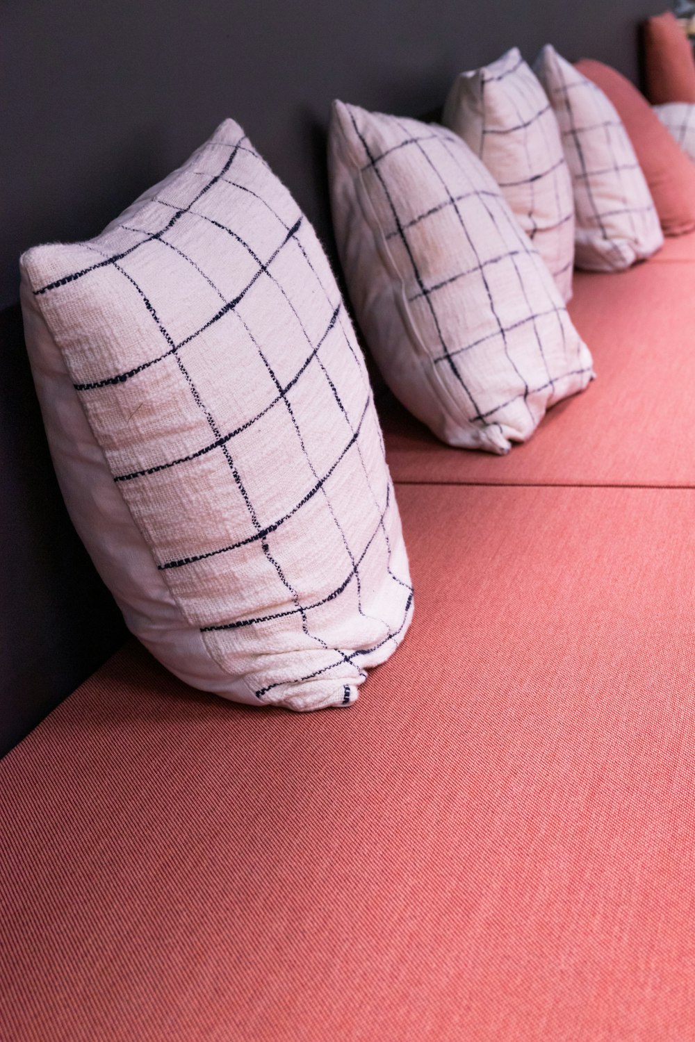 white and black throw pillows on red textile