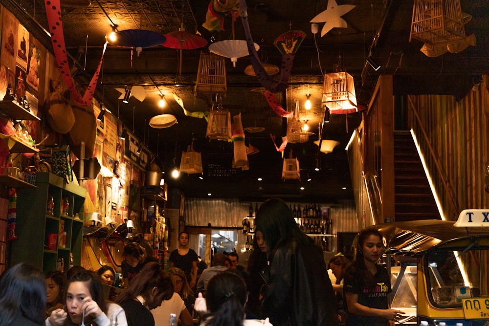 people standing and sitting inside restaurant