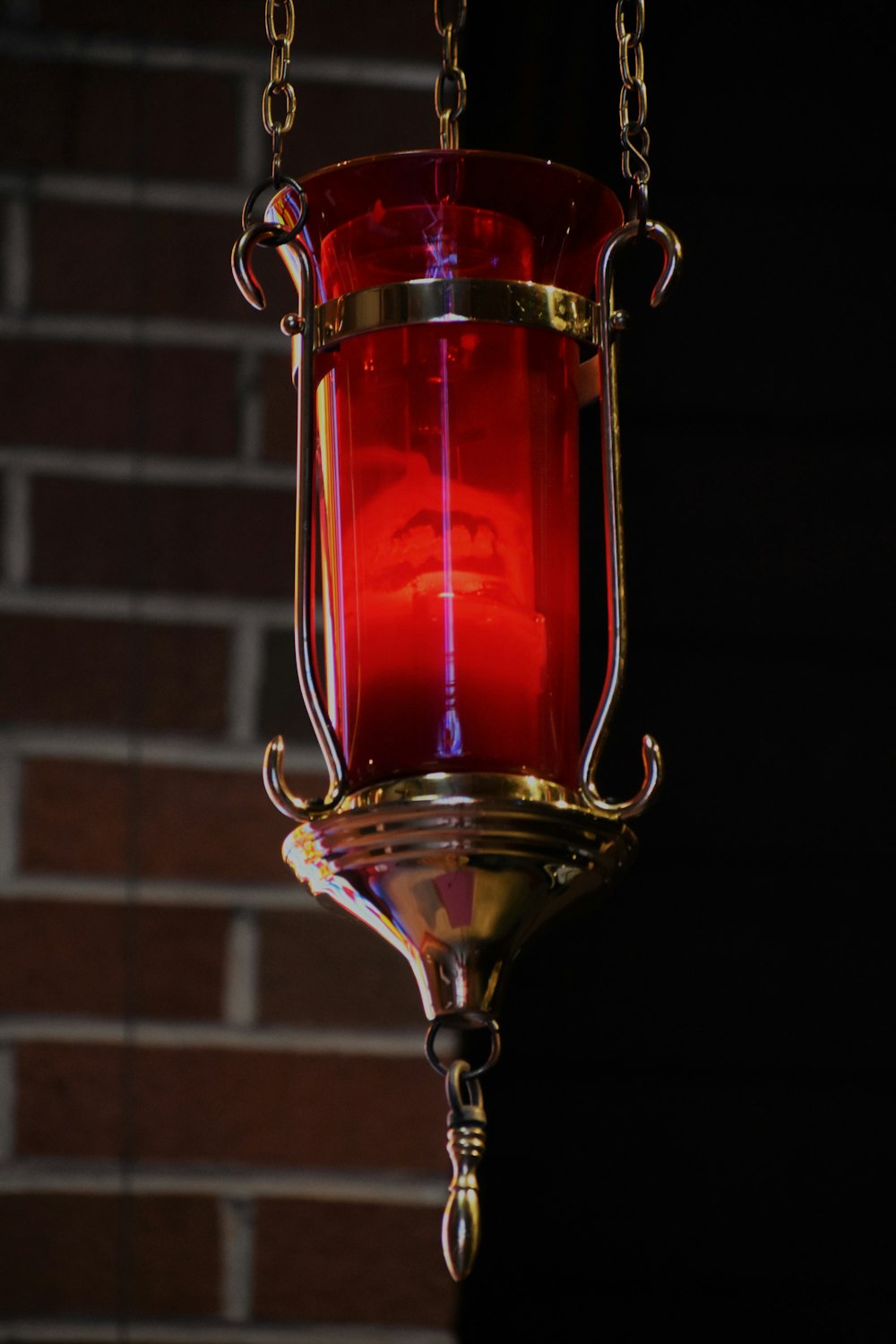 red and gold lamp near brown brick wall