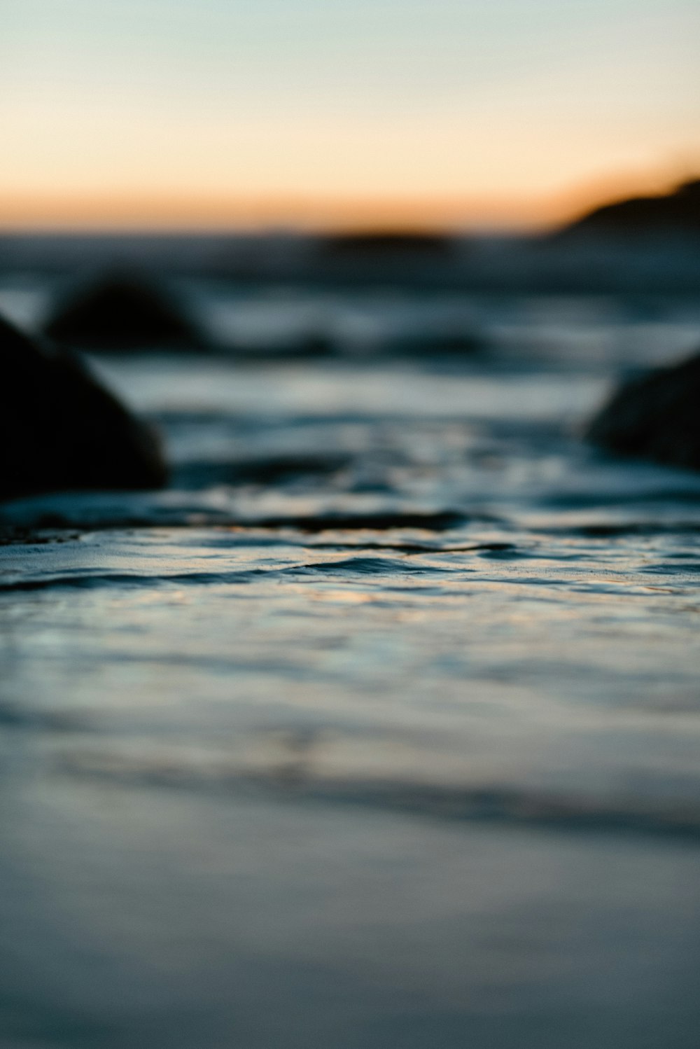 Wasserwellen an Land während des Sonnenuntergangs