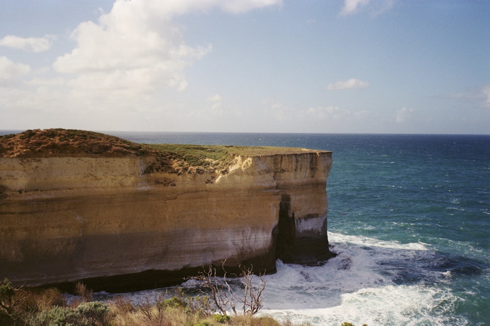 brown rock formation near body of water during daytime