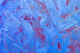 An abstract composition of overlapping wooden textures in shades of blue with accents of red, creating a dynamic and layered effect.