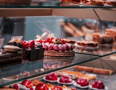 strawberry and blackberry on clear glass display counter